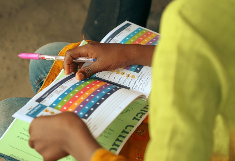 A child engages with a colorful educational booklet, holding a pen.