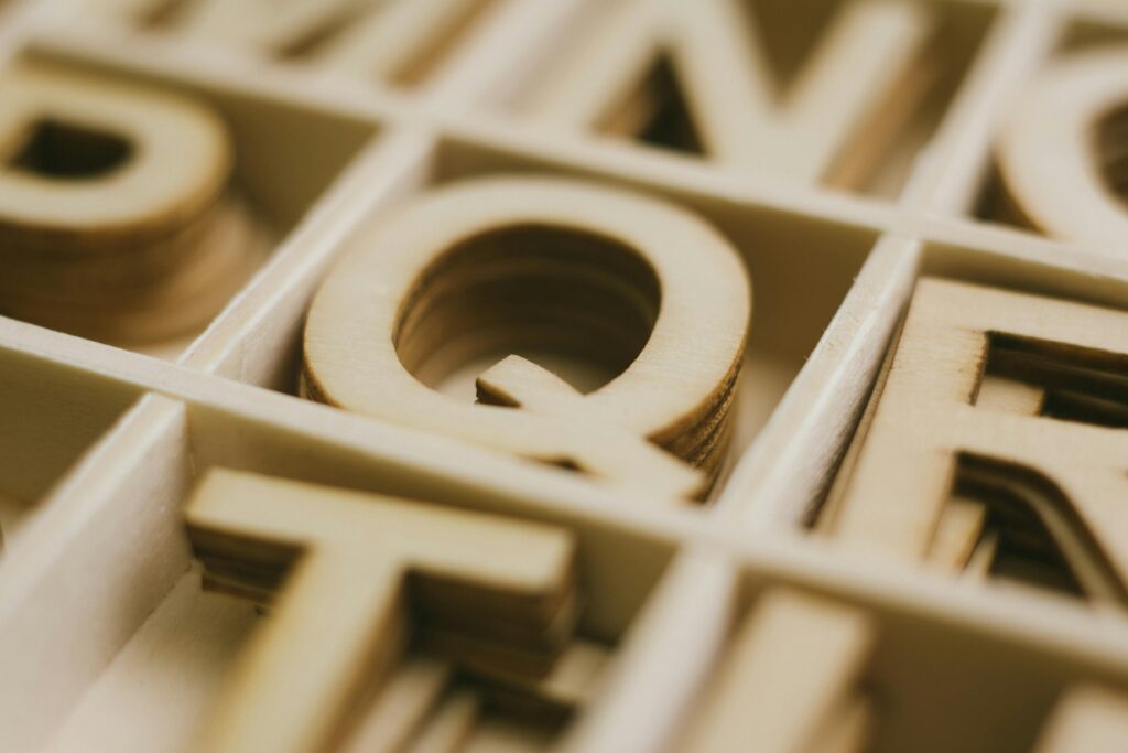 Detailed close-up view of organized wooden alphabet letters in a box for crafts or design projects.